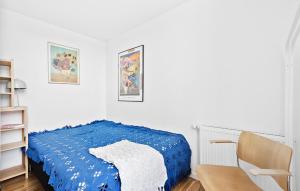 um quarto com uma cama azul e uma cadeira em Amazing Home In Niv With Kitchen em Nivå