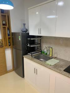 胡志明市的住宿－The Everich Infinity 290 ADV，厨房配有水槽和冰箱