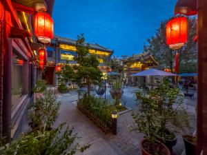 une cour avec des plantes et des bâtiments la nuit dans l'établissement Datong Yunzhong Traditional Courtyard, à Datong