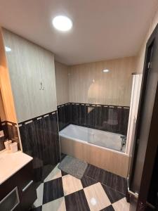 卡巴內斯的住宿－adosado unifamiliar，带浴缸的浴室和 ⁇ 格地板