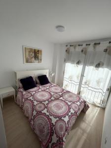 卡巴內斯的住宿－adosado unifamiliar，一间卧室配有一张带红白毯子的床