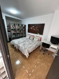 1 dormitorio con cama, escritorio y ordenador en adosado unifamiliar, en Cabanes