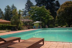 ein Pool mit zwei Bänken im Hof in der Unterkunft Hotel Lago Los Molinos in Villa Ciudad de America