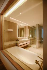 baño grande con bañera y lavamanos en Ha Long Bay A La Carte Apartment By The O Residence, en Ha Long