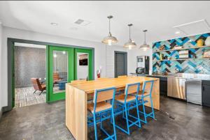 uma cozinha com uma mesa de madeira e cadeiras azuis em Comfy& stylish ~2bed~2Bath ~8 minute to Downtown em Austin