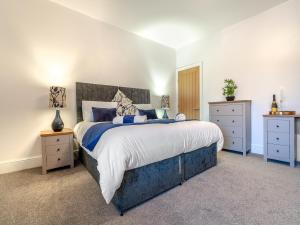 a bedroom with a large bed and two night stands at Appletree Cottage in Cornsay