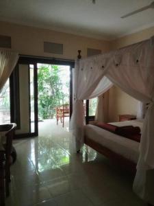 a bedroom with two beds and a large sliding glass door at Pondok Aldi Hostel in Amed