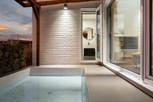 a bath tub in a room with a large window at Tov & Kara in Jeju