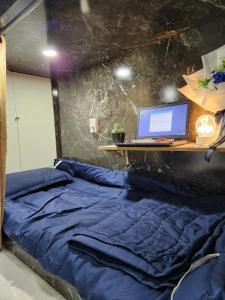 a bedroom with a bed with a computer on a desk at D-Dorm Home in Ho Chi Minh City