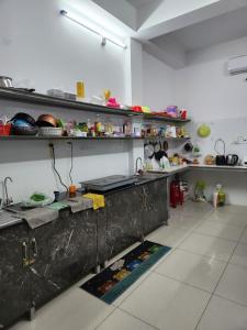 a kitchen with a counter and shelves with food at D-Dorm Home in Ho Chi Minh City