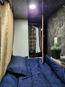 a bedroom with a blue bed and a mirror at D-Dorm Home in Ho Chi Minh City