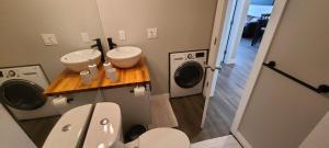 a bathroom with a sink and a washing machine at Howe Street Apartment with Views in Vancouver