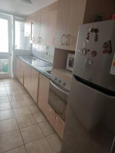 a kitchen with white cabinets and a white refrigerator at Espectacular departamento en Santiago centro. in Santiago