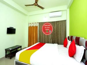 um quarto com uma cama grande e almofadas vermelhas em Goroomgo Shree Bhumi Puri Near Sea Beach - Best Hotel in Puri em Puri