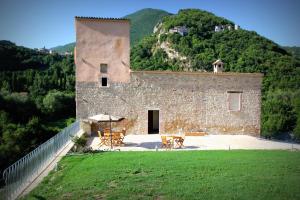 un edificio con mesas y sillas delante de él en Agriturismo Casale La Palombara, en Cerreto di Spoleto