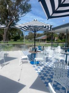 a group of white chairs and tables with umbrellas at Coastal Springs - PET FRIENDLY & 200m To Beach! in Clifton Springs