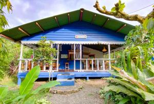 a blue house with a green roof at Hotel Casitas Mar y Luz in Puerto Viejo