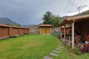 un patio trasero de una casa con césped en QHAPAQ WASI, en Cusco