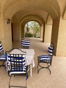 托澤爾的住宿－SANDROSE，庭院配有蓝色和白色的椅子和桌子