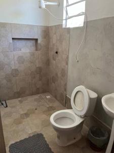 La salle de bains est pourvue de toilettes et d'un lavabo. dans l'établissement Casa em Santa Cruz Cabrália, à Santa Cruz Cabrália