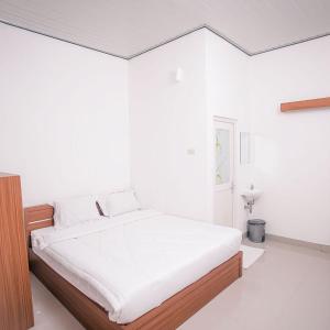 Un dormitorio blanco con una cama grande. en Tera Guest House, en Kedaton