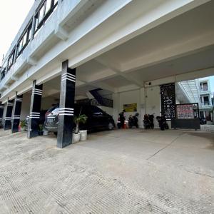 a parking garage with cars and motorcycles parked in it at Tera Guest House in Kedaton