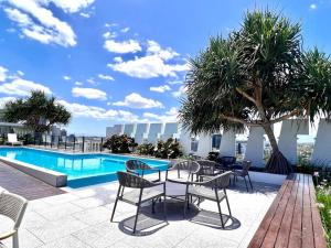 een patio met een tafel en stoelen naast een zwembad bij Southbank One Bedroom Home with Free Parking in Brisbane