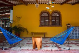 dwa niebieskie krzesła w pokoju z żółtą ścianą w obiekcie Casas México 1 w mieście San Antonio