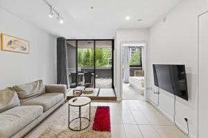 een woonkamer met een bank en een tv bij Southbank One Bedroom Home with Free Parking in Brisbane