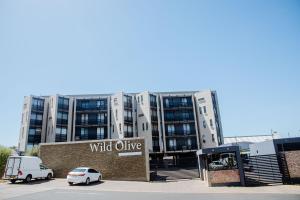 a building with a wild olive sign in front of it at One bedroom flat in Wild Olive apartments in Windhoek