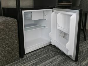 an empty refrigerator with its door open in a room at HOTEL NOIR Kagoshima Chuo Station in Kagoshima