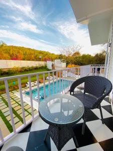 uma varanda com mesa e cadeiras e uma piscina em Tvessa - A Boutique Hotel em Mandrem