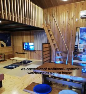 a room with a wooden wall with a wooden staircase at くまの蔵inn Warehouse in Shingu