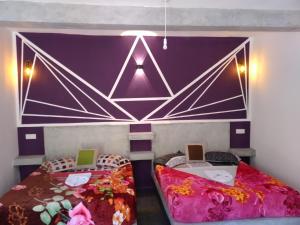 2 Betten in einem Zimmer mit lila Wänden in der Unterkunft Hugging Clouds in Nallathanniya