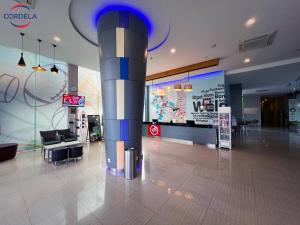 a lobby with a column in the middle of a building at Cordela Kartika Dewi Yogyakarta in Yogyakarta