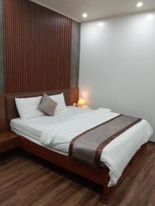 a bedroom with a large bed with white sheets at Tam Đảo Hotel in Tam Ðảo