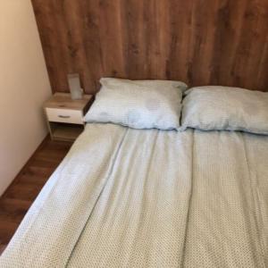 ein Bett mit zwei Kissen darauf in einem Schlafzimmer in der Unterkunft Tulipán Apartman in Eger