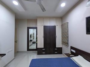 a bedroom with a blue bed and a mirror at Soul House_4.5 BHK Apartment in Ahmedabad