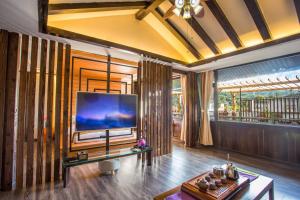 a living room with a large flat screen tv at Tengchong Old Town Peace Inn in Tengchong