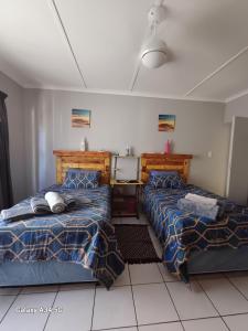 - une chambre avec 2 lits et du carrelage blanc dans l'établissement GAV'Z Guesthouse, à Richards Bay