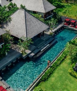 an overhead view of a swimming pool with a person standing in the water at La Reserve 1785 Canggu Beach in Canggu