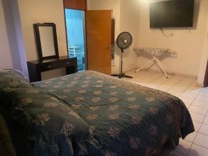 a bedroom with a bed and a fan and a television at Departamentos grandes y centricos. in Poza Rica de Hidalgo