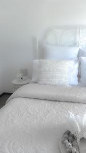 a white bed with white sheets and pillows at Coastal Springs - PET FRIENDLY & 200m To Beach! in Clifton Springs