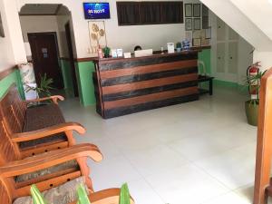 a waiting room with wooden benches and a counter at SG Hotel in El Nido