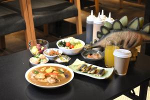 une table avec des bols de nourriture et un dinosaure dessus dans l'établissement Henn na Hotel Tokyo Nishikasai, à Tokyo