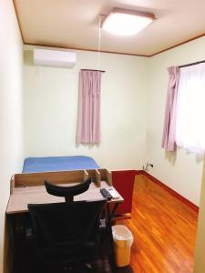a room with a bed and a desk and a table at Joya in Ishigaki Island