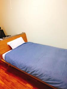 a bed with a blue comforter and a white pillow at Joya in Ishigaki Island