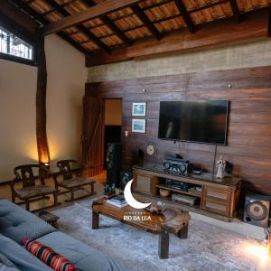 a living room with a couch and a flat screen tv at Casa da Mata - Sao Jorge GO in Sao Jorge
