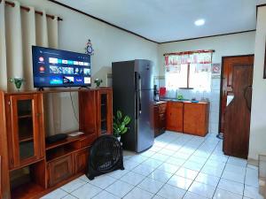 a kitchen with a refrigerator and a flat screen tv at Casa equipada en el centro de Puntarenas in Puntarenas