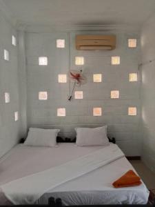 een slaapkamer met een bed en een rode bloem aan de muur bij Kep Family House & Restaurant in Phumĭ Ŏng Char